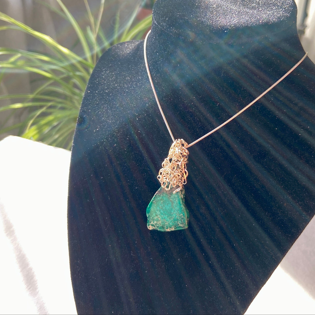 Green Jasper stone pendant on a black display