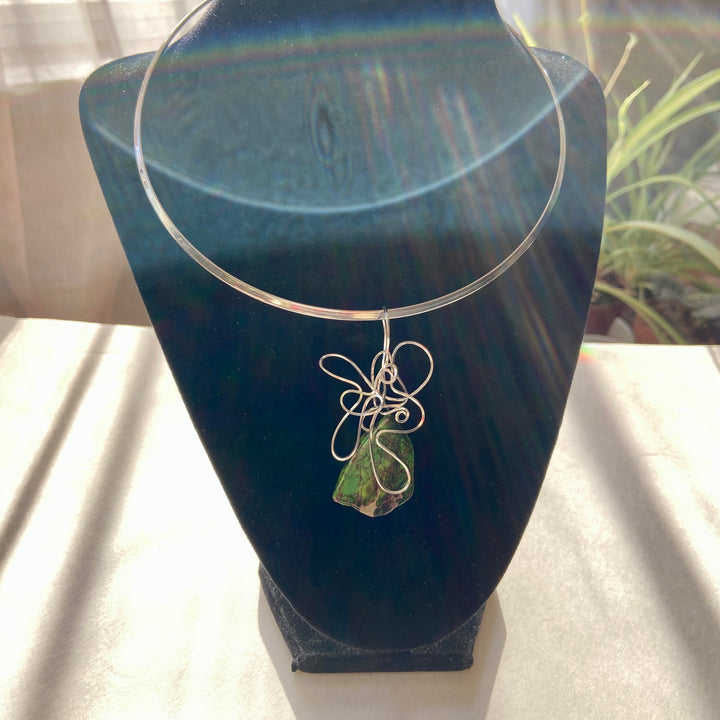 Green Jasper stone pendant with silver wire wrapping on a black display