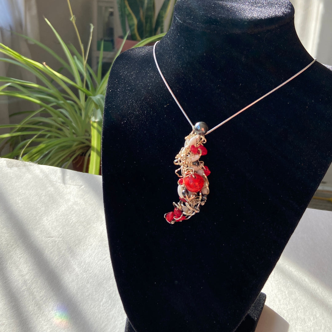 Necklace with red Jasper stones and beads on a black display