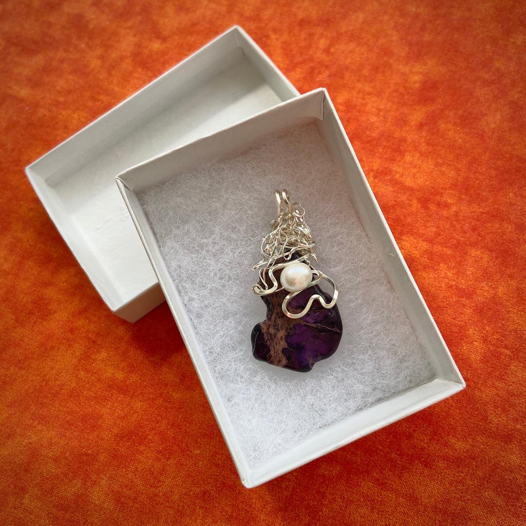 Purple Jasper stone pendant with pearl in a white box on an orange background