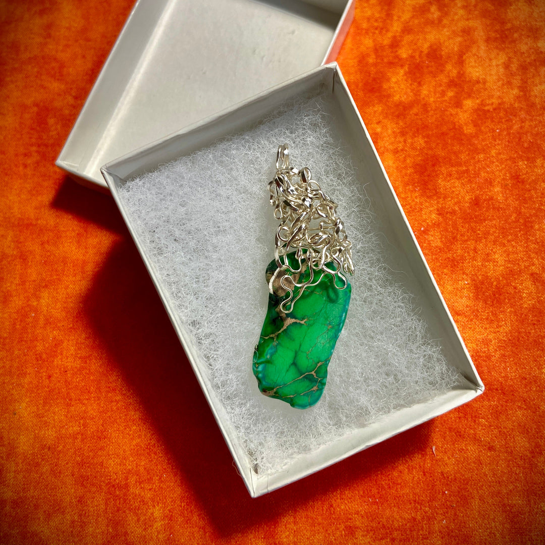 Jewelry box with a green Jasper gemstone pendant, wire-wrapped,  on an orange background