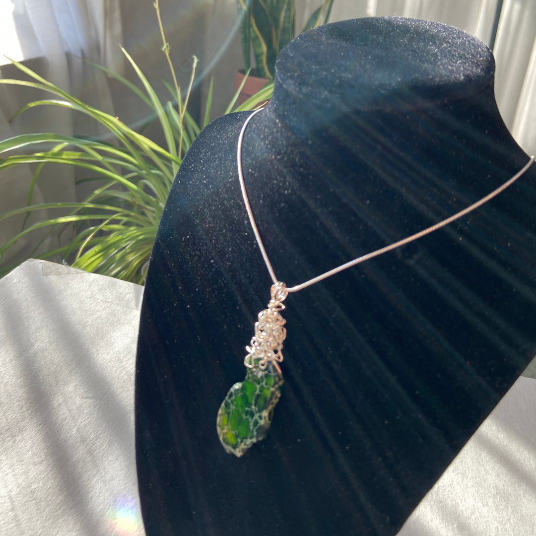 Necklace with a green Jasper stone pendant on a black velvet stand