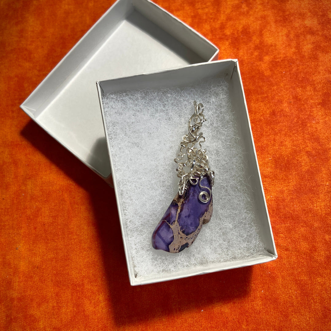 Jewelry box with a purple Jasper pendant on an orange background