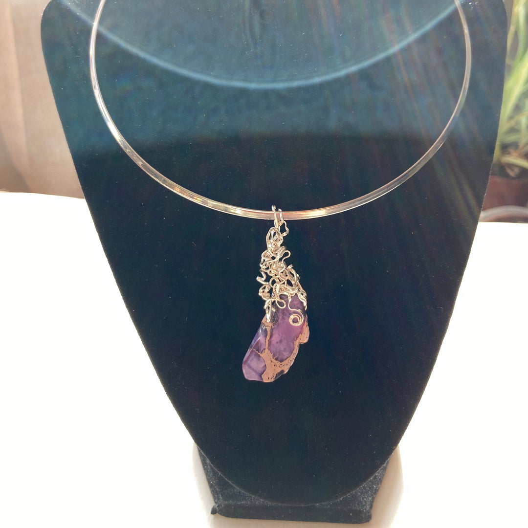 Necklace with a purple Jasper stone pendant t on a black stand
